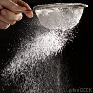 confectioners-sugar-being-sprinkled-with-a-sifter